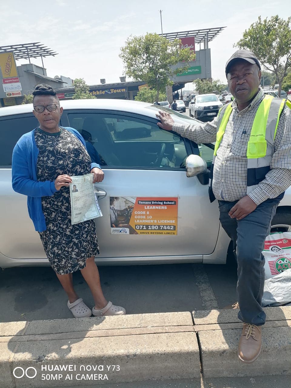 Temane instructor training a learner driver in a modern vehicle
